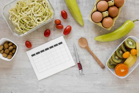 Alimentos sobre una mesa y un planning de comidas